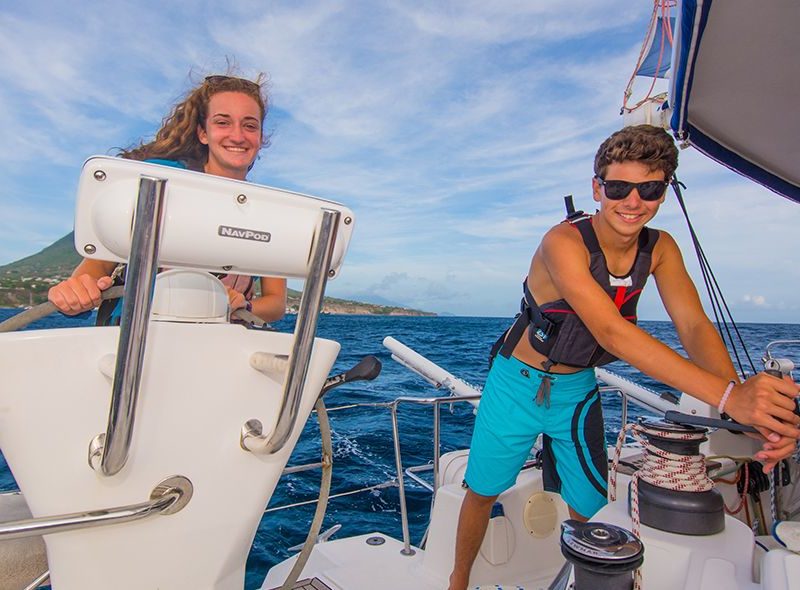 Teens sailing catamaran on summer sailing program for high school students