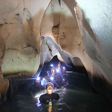 Teens swimming in cave on marine biology summer programs