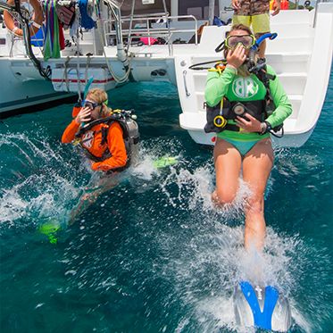 Divers jumping from boat on padi Divemaster course