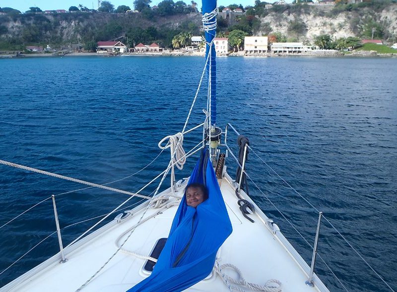 Student in hammock on sailboat on summer sailing program for teenagers