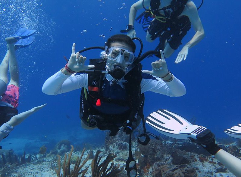 Middle school teens scuba diving on Caribbean summer underwater camp