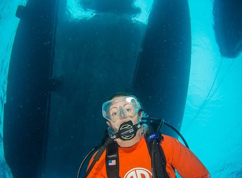 Diver swimming under boat on diving internships Caribbean