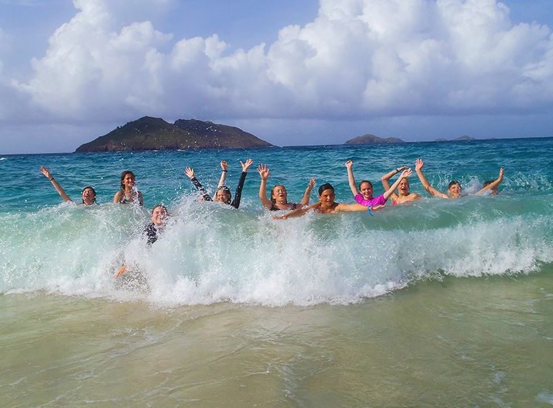 Teens body surfing in waves in St Barths on summer scuba camp