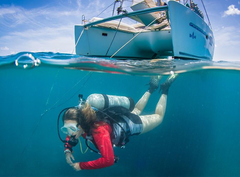 Diver swimming under boat on padi divemaster course