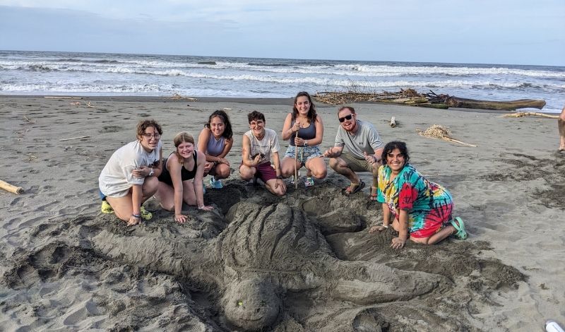 high school students study sea turtles on beach in Costa Rica during summer marine biology program