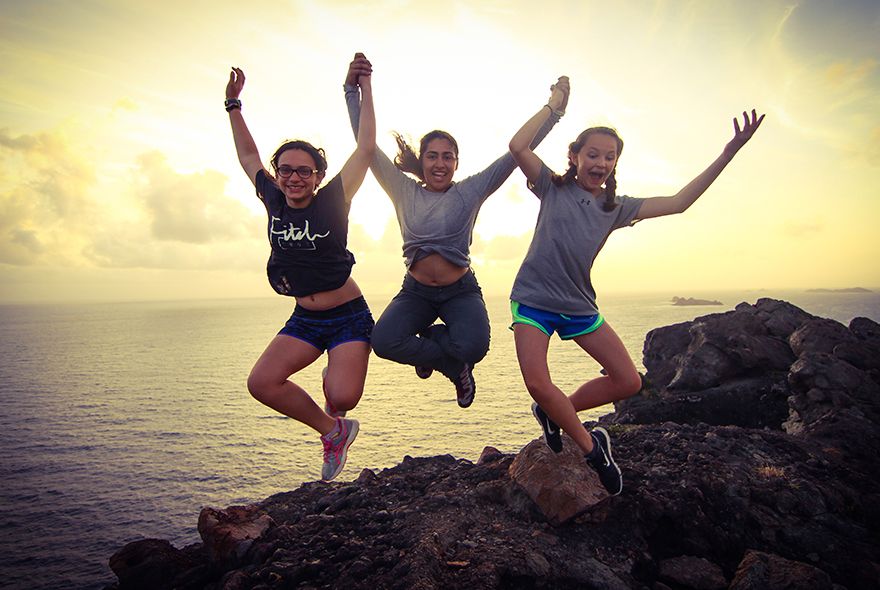 Teens jumping after completing hike to watch sunset Caribbean teen adventures