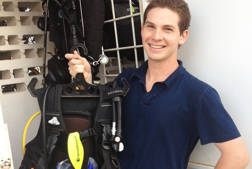 Student trying on dive gear on summer diving internship abroad