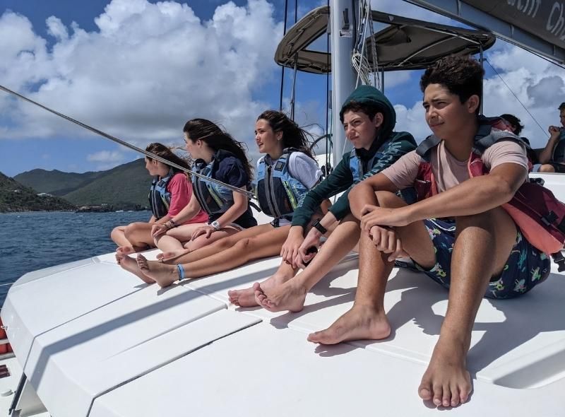 Middle schoolers sit on catamaran during Caribbean intro to marine bio camp