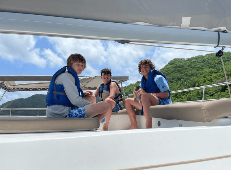 Middle school students hang out on catamaran on advanced scuba trip