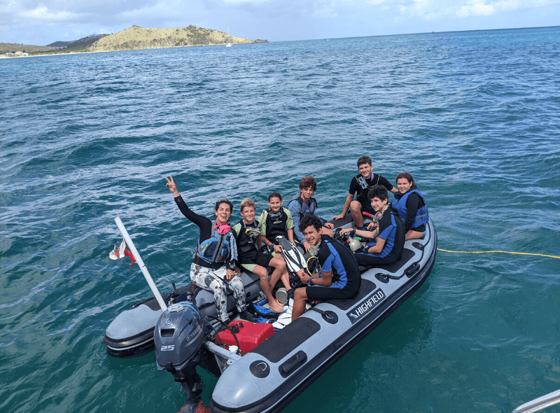 Middle school students in dive gear in dingy on Advanced Scuba camp