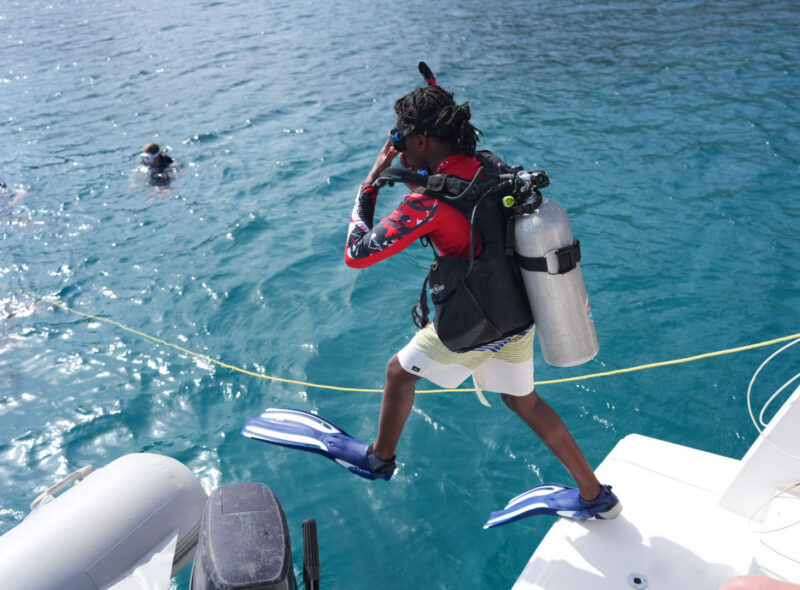 teen diving off boat on caribbean marine science summer camp