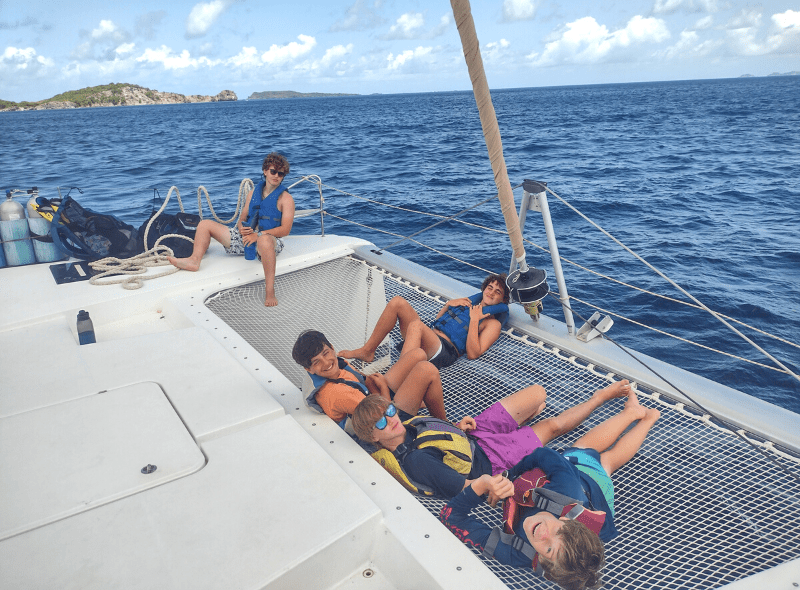 Teens on catamaran during advanced dive trip through Windward islands
