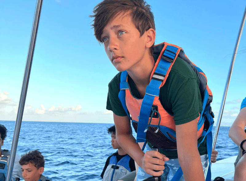 Middle school student sails catamaran during summer dive and sail camp