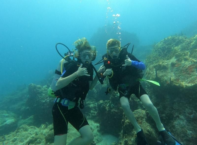 Teen boys scuba diving during marine biology camp