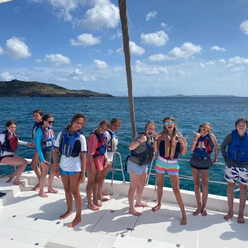Middle school students on bow of catamaran at summer sailing camp