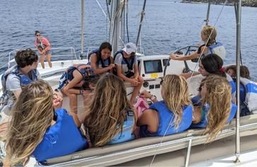 Teens at helm of sailboat on Caribbean sailing camp