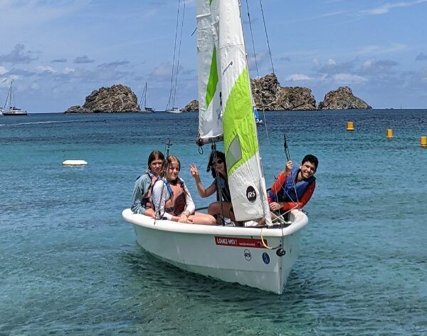 Teens sailing dinghy in Caribbean on summer sailing program