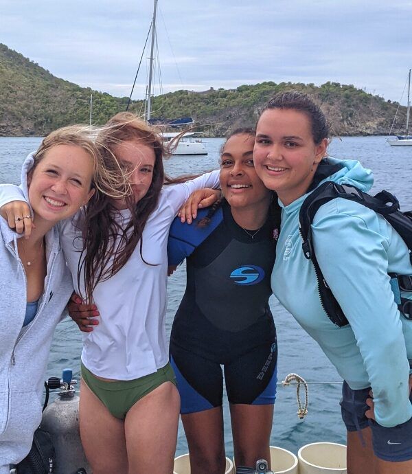 Teens in scuba gear on catamaran for sailing and diving summer program
