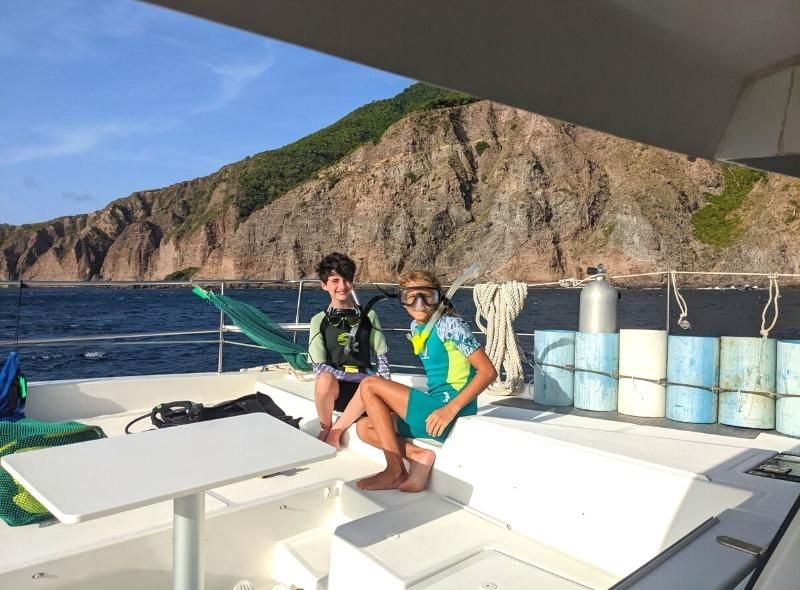 Two middle school students wearing scuba gear on boat in Caribbean for summer program