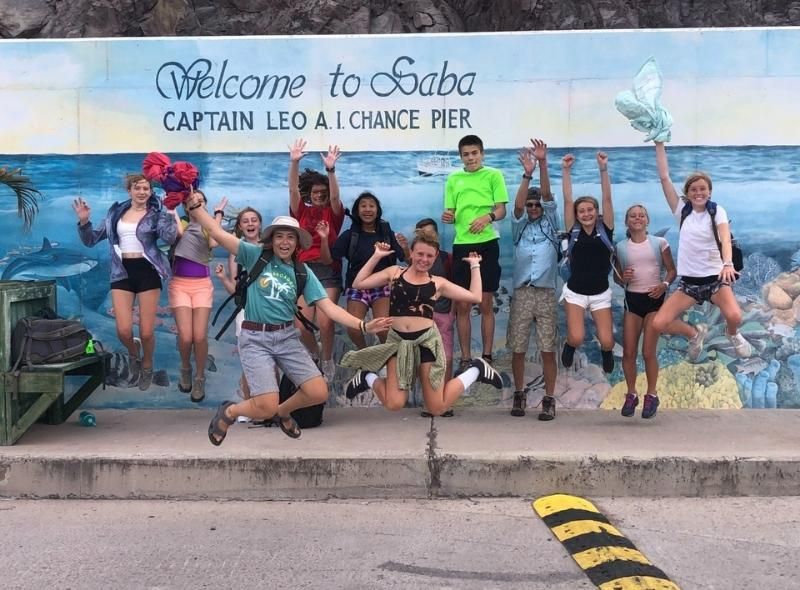 Group of middle school students jump on Saba during summer dive program