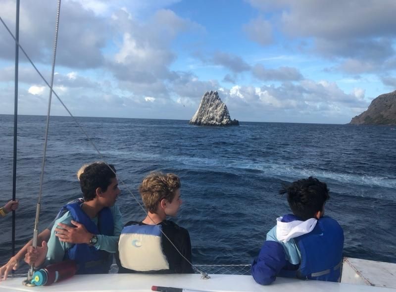 Middle school boys on catamaran look at Caribbean islands on scuba program