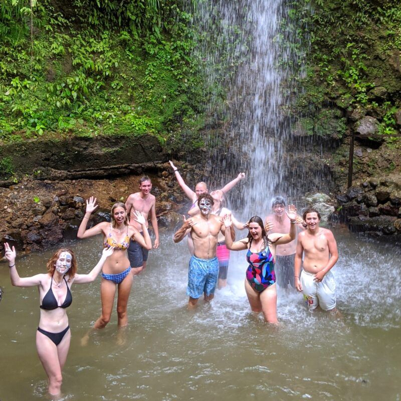High school students visit waterfall on Caribbean island during advanced sailing voyage