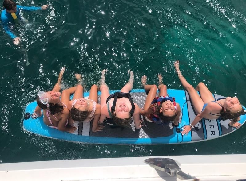 Middle school girls on paddleboard in Caribbean on middle school summer camp abroad