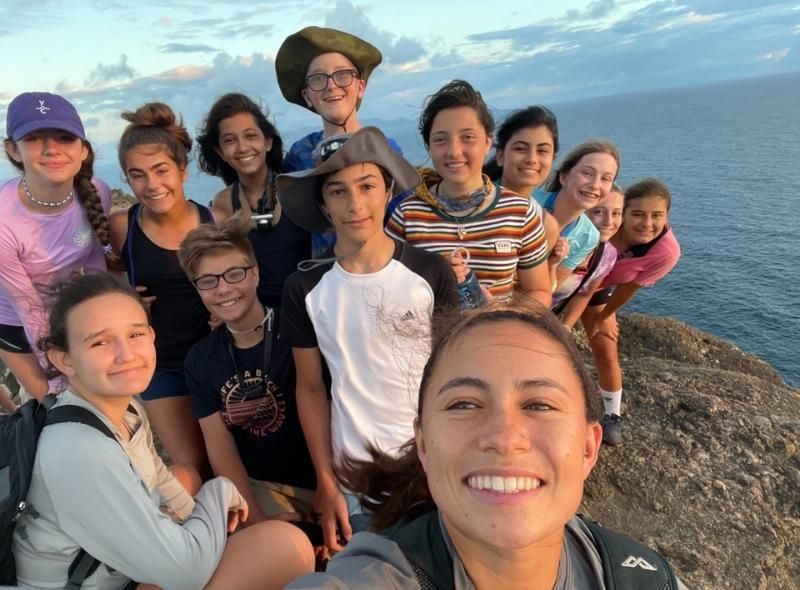 Group of middle school students on cliff over the sea during Caribbean dive and sail summer program for middle school students
