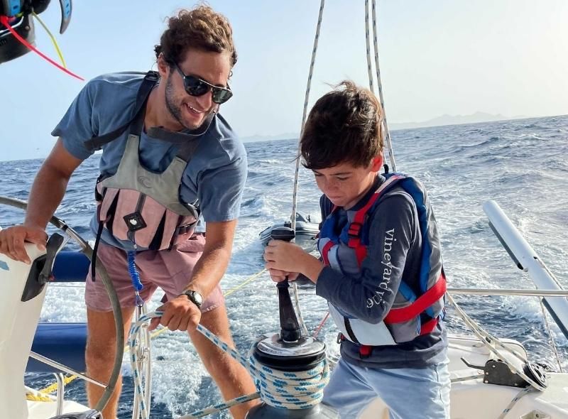 Instructor teaches middle school boy to sail during middle school summer program in Caribbean