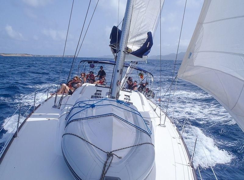 Group of high school students on monohull during summer sailing camp