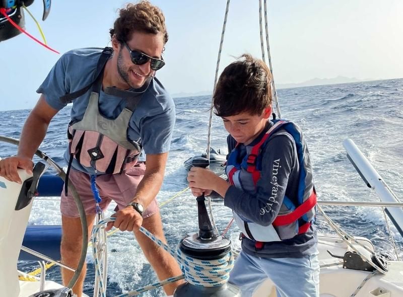 instructor teaches middle school student to use winch on summer sailing camp