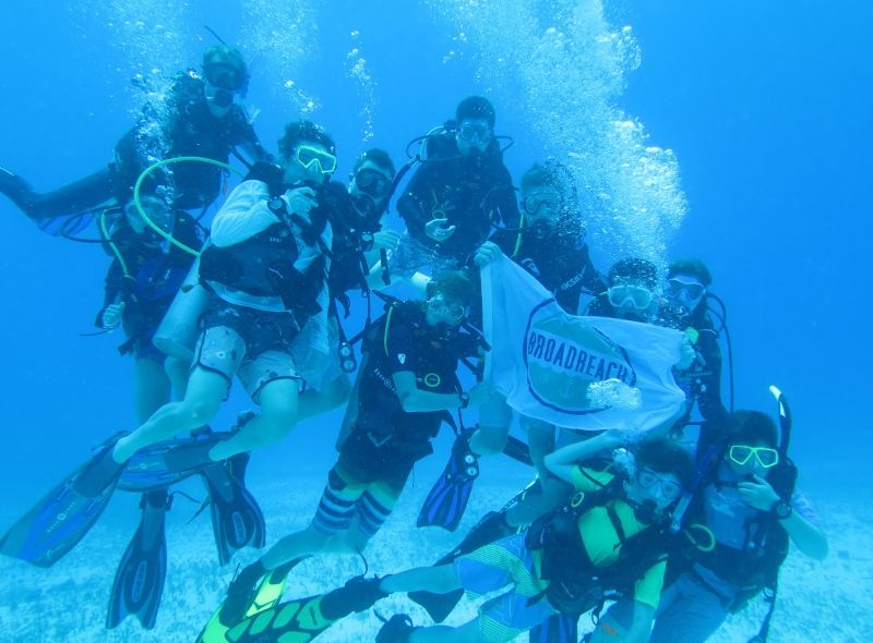 Group of high school students scuba dive on summer marine conservation program