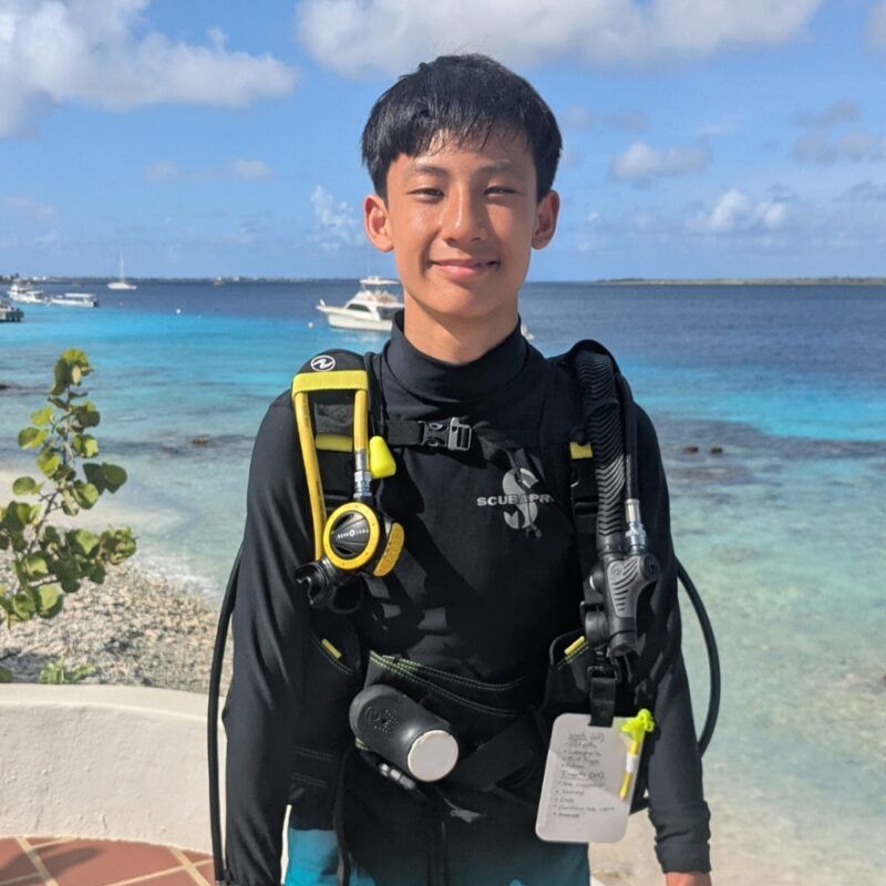 Middle school student in scuba gear posts near shore on Bonaire scuba and marine biology trip