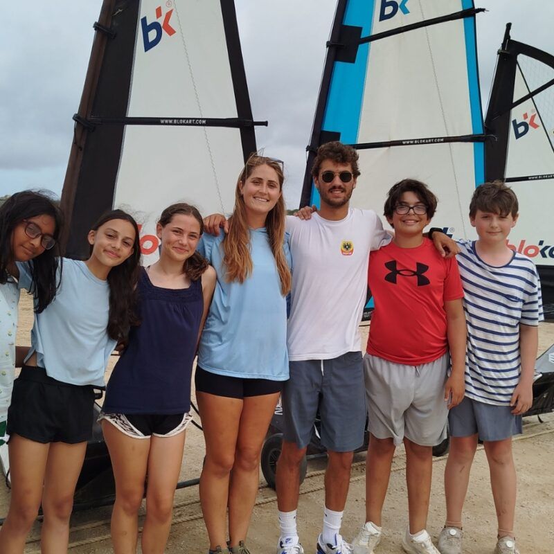 Middle school students pose in front of landsailing carts