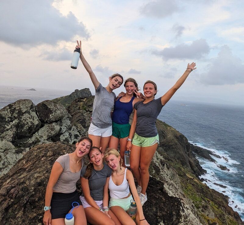 group of middle school students pose at top of mountain in Caribbean 