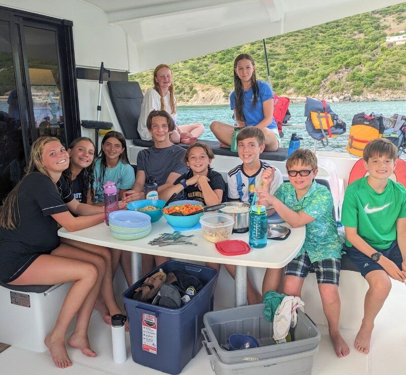 middle school students at table on catamaran in Caribbean