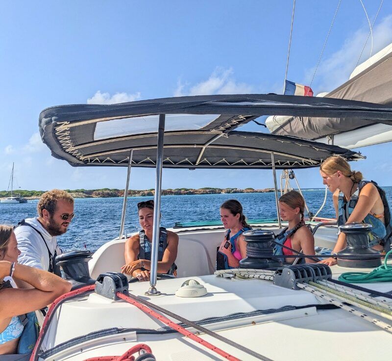 Sailing instructor works with middle school students on catamaran in Caribbean