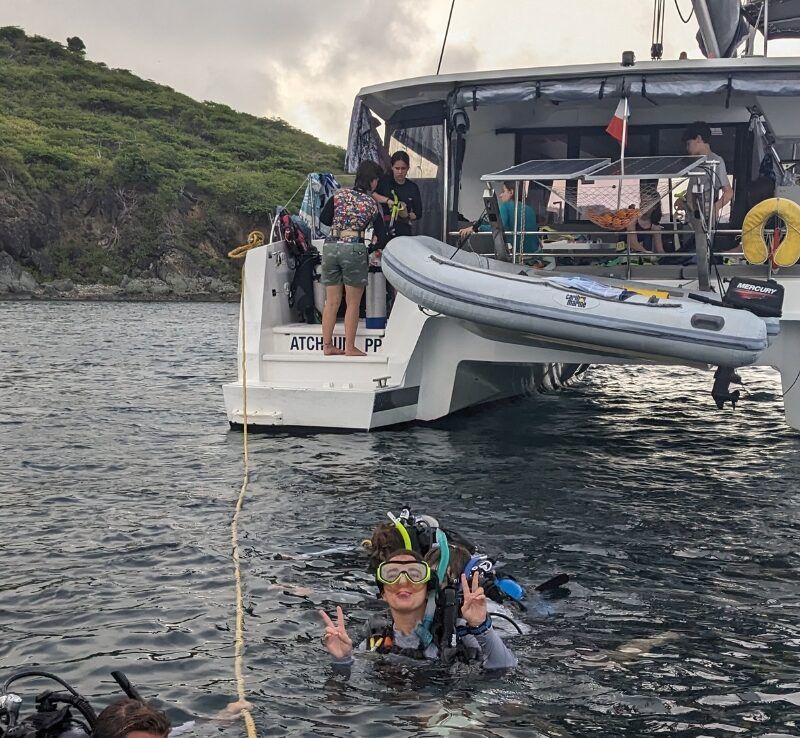Students in dive gear in water near catamaran in the Caribbean