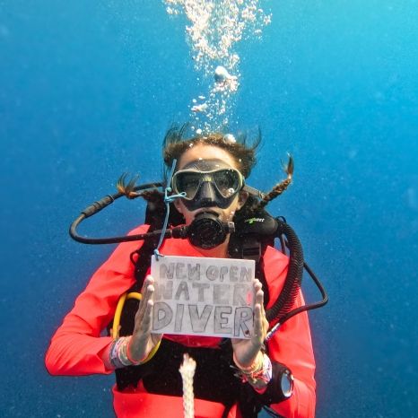 middle school diver underwater holds new open water diver sign