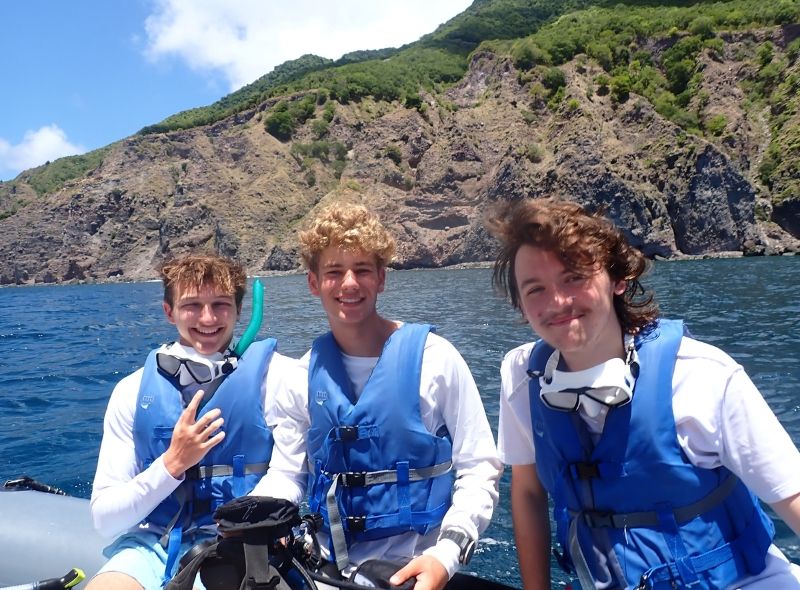 three high school students on boat in the Caribbean during summer program
