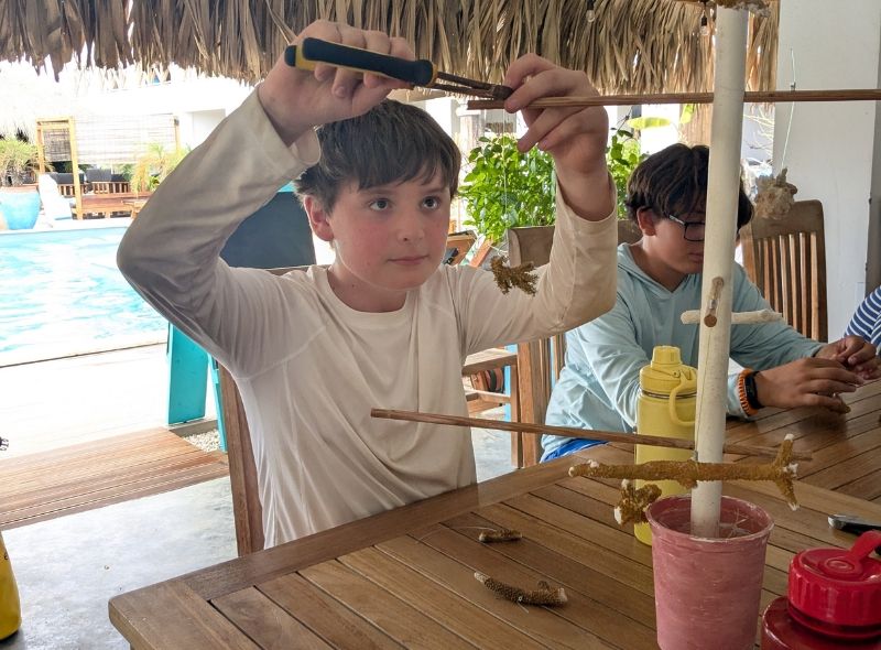 middle school student assists with coral nursery at marine biology camp