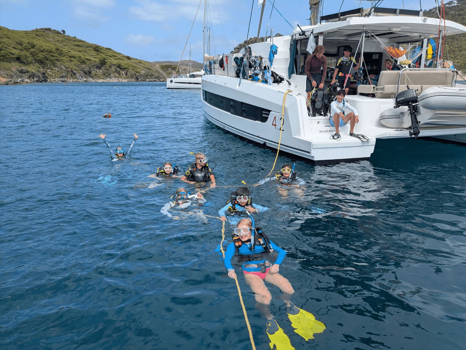 middle school students at surface in scuba gear near catamaran on Caribbean dive and sail program